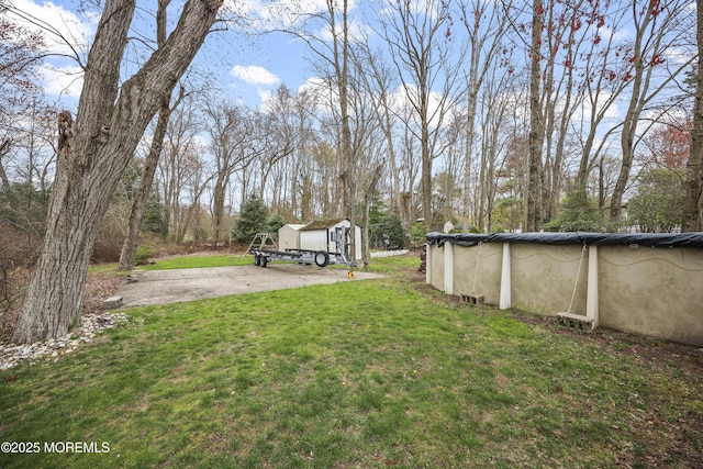 view of yard with a storage unit, an outbuilding, and an outdoor pool
