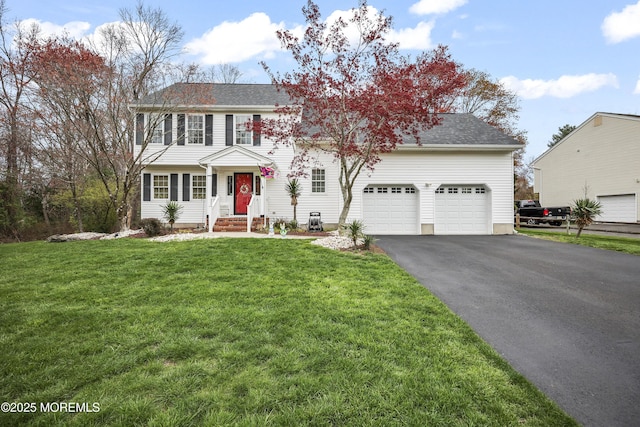 view of front of property featuring an attached garage, driveway, and a front lawn
