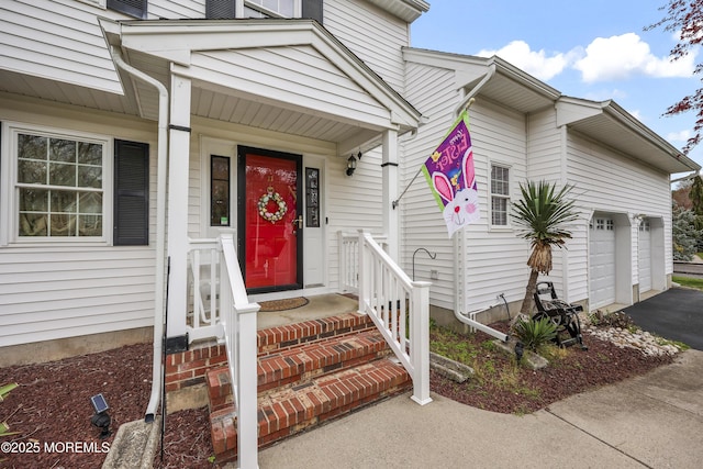 view of exterior entry featuring a garage and driveway