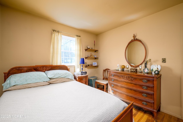 bedroom featuring baseboards and wood finished floors