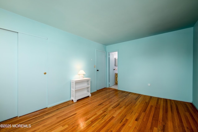 unfurnished bedroom featuring a closet and light wood-style flooring