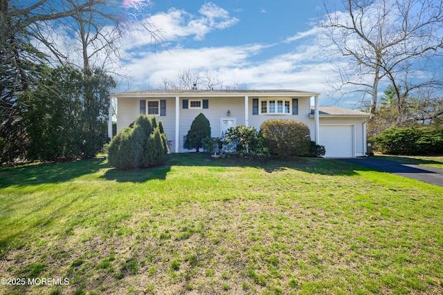 view of front of house featuring a garage, aphalt driveway, and a front lawn