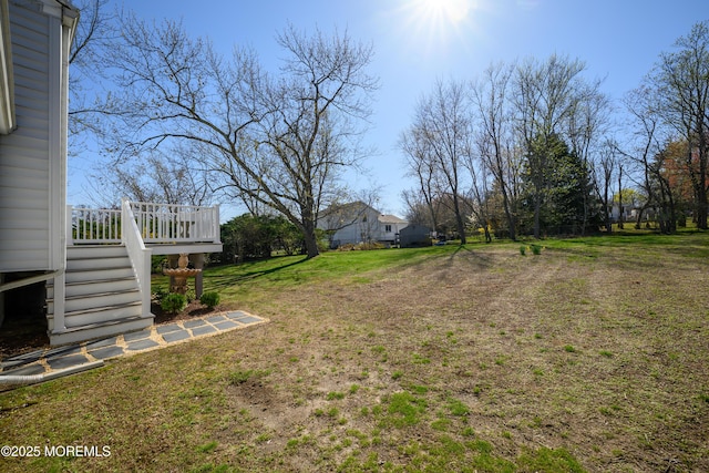 view of yard featuring stairs and a deck