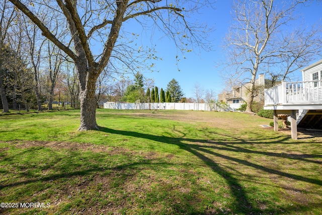view of yard with a deck and fence