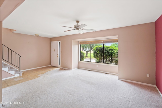 unfurnished living room featuring ceiling fan, baseboards, carpet flooring, and stairs