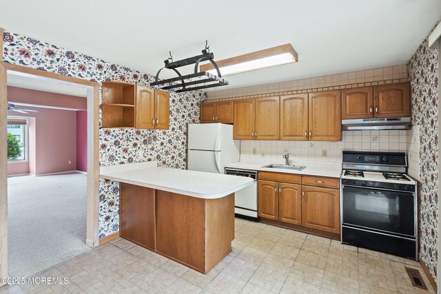 kitchen with white appliances, a sink, under cabinet range hood, open shelves, and light countertops