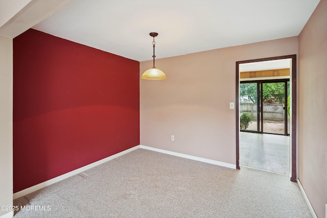 carpeted spare room featuring baseboards