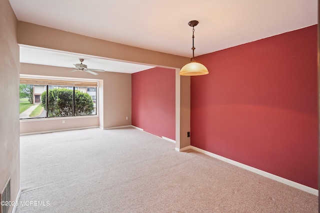 empty room featuring carpet floors, a ceiling fan, and baseboards