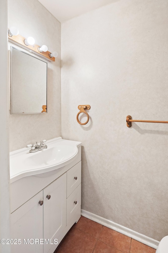 bathroom with vanity, baseboards, and tile patterned flooring