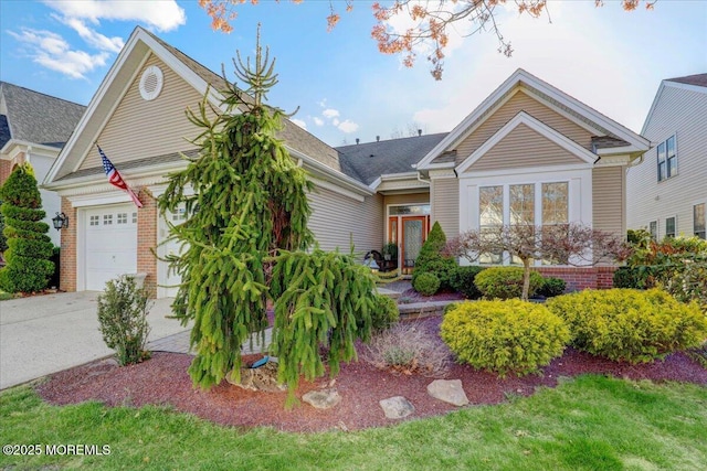 craftsman house featuring an attached garage, driveway, and brick siding