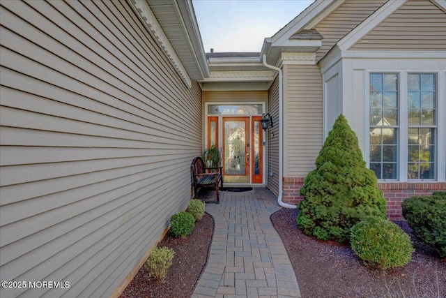 view of exterior entry featuring brick siding