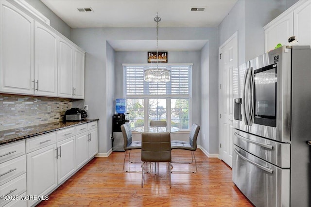 kitchen with stainless steel fridge with ice dispenser, visible vents, white cabinetry, and a chandelier