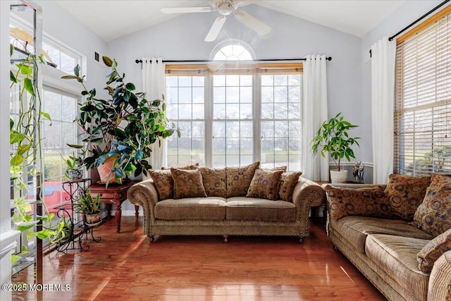 living area with wood finished floors, a ceiling fan, and vaulted ceiling