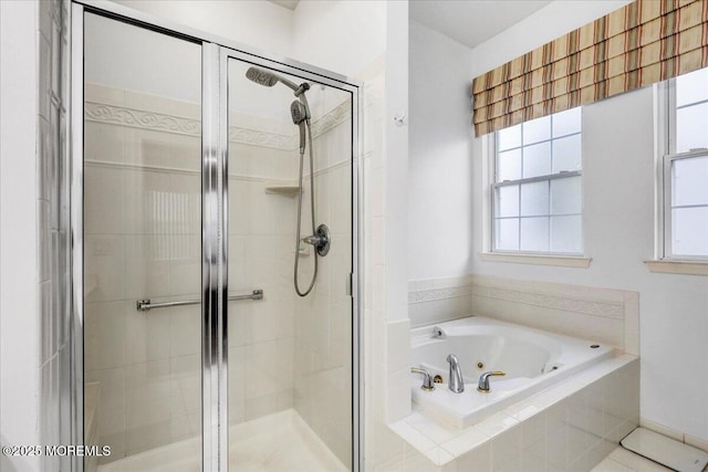 bathroom with a shower stall, a jetted tub, and a healthy amount of sunlight