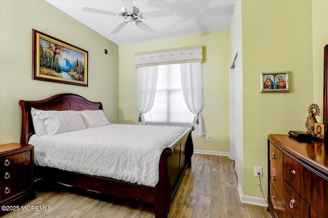 bedroom with visible vents, baseboards, ceiling fan, and wood finished floors