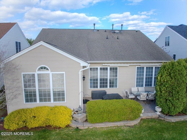 back of property with an outdoor living space, a shingled roof, and a patio area