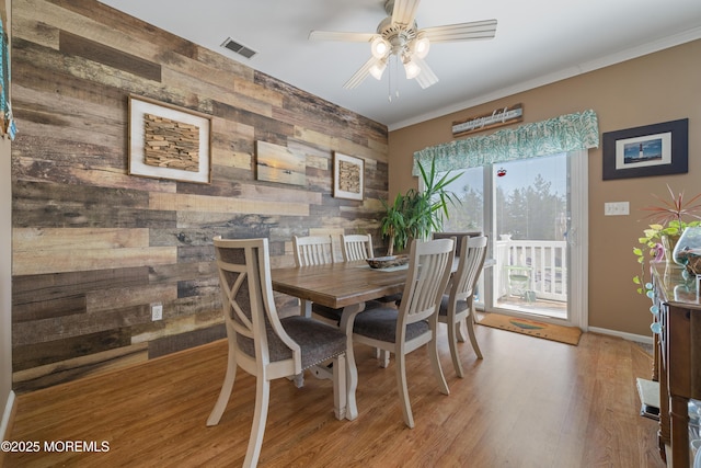 33 Blue Heron Ln, Bayville, NJ 08721 - dining area with an accent wall, a ceiling fan, light wood-type flooring, and wooden walls