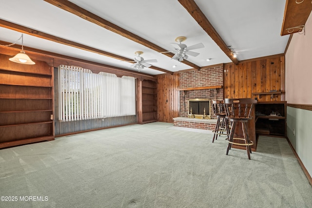 36 New Monmouth Rd, Middletown, NJ 07748 - unfurnished living room featuring carpet flooring, a ceiling fan, wooden walls, beam ceiling, and a fireplace