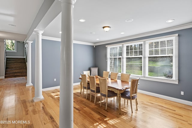 dining space featuring baseboards, ornamental molding, recessed lighting, light wood-style flooring, and ornate columns