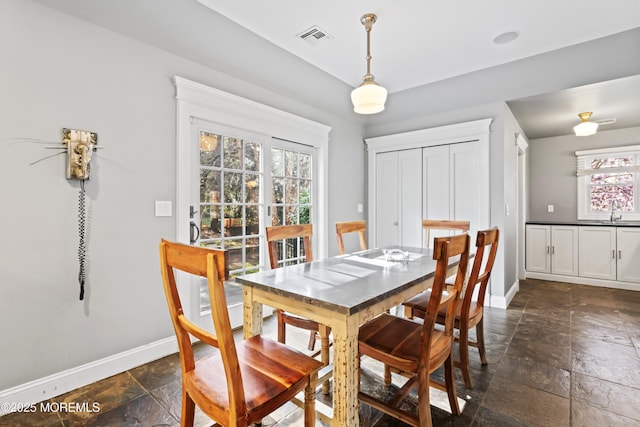 dining space with visible vents, baseboards, and stone tile flooring