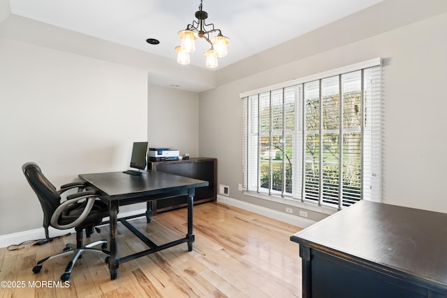 home office featuring light wood finished floors, an inviting chandelier, and baseboards