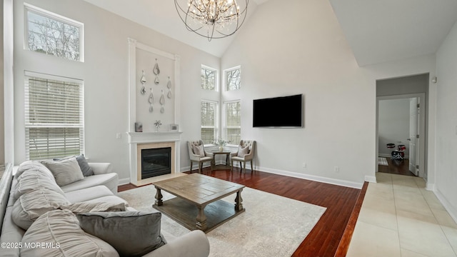 101 Erin Dr, Jackson, NJ 08527 - living area with baseboards, a glass covered fireplace, high vaulted ceiling, and a notable chandelier