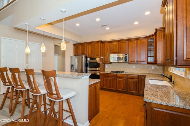 7 Riviera Dr, Monroe, NJ 08831 - kitchen featuring a sink, light wood-type flooring, brown cabinetry, stainless steel appliances, and decorative backsplash