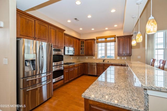 7 Riviera Dr, Monroe, NJ 08831 - kitchen featuring light wood-type flooring, backsplash, visible vents, brown cabinetry, and stainless steel appliances