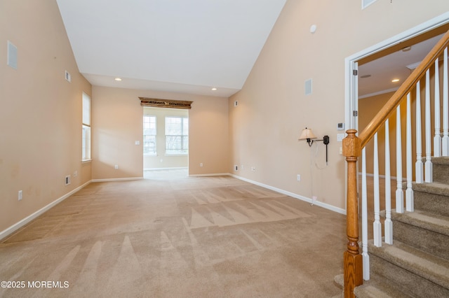 7 Riviera Dr, Monroe, NJ 08831 - unfurnished living room featuring light colored carpet, recessed lighting, stairway, a high ceiling, and baseboards