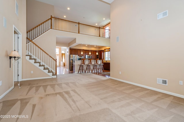 7 Riviera Dr, Monroe, NJ 08831 - unfurnished living room with light colored carpet, baseboards, visible vents, and stairway