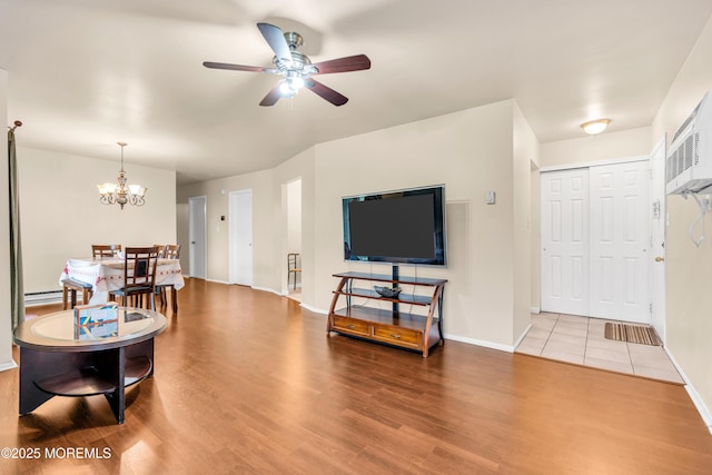 54 Amberly Dr Unit F, Manalapan, NJ 07726 - living room with a baseboard radiator, ceiling fan with notable chandelier, baseboards, and wood finished floors
