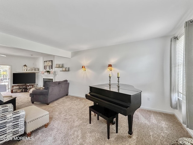 carpeted living area featuring baseboards and a fireplace