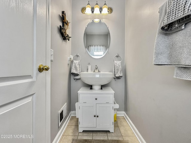 bathroom featuring a sink, visible vents, tile patterned floors, and baseboards