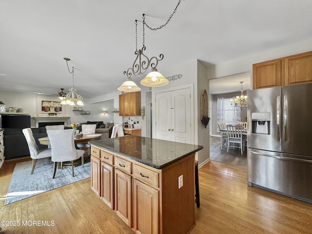 kitchen featuring a chandelier, light wood-type flooring, stainless steel fridge, and a kitchen island