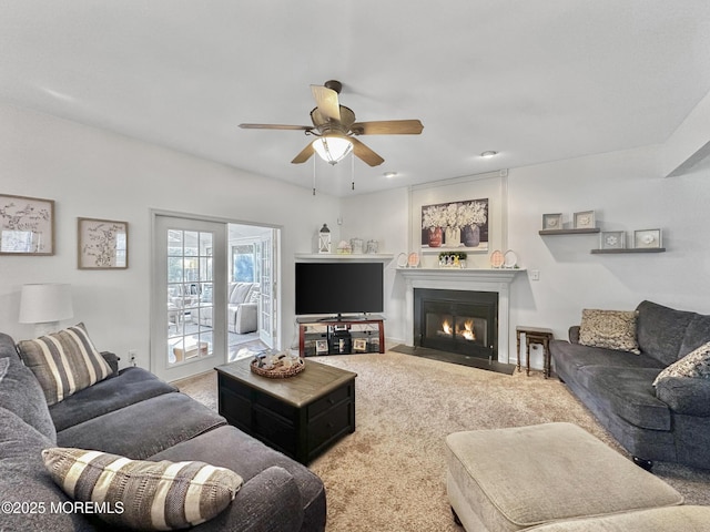 living room with a fireplace with flush hearth, carpet, and ceiling fan
