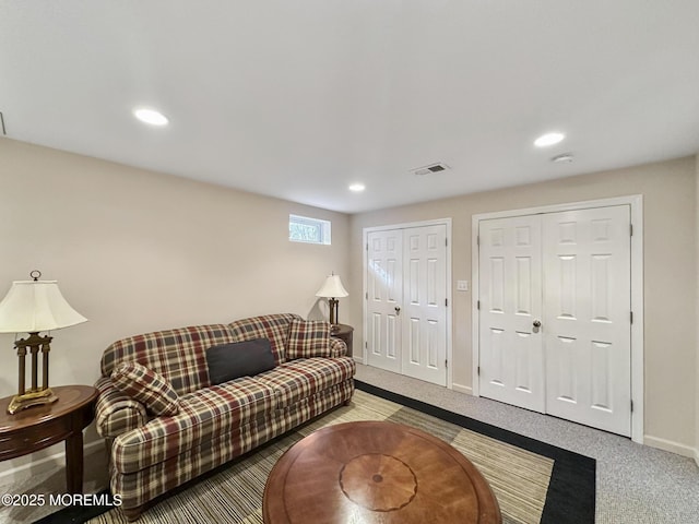 carpeted living room with visible vents, baseboards, and recessed lighting
