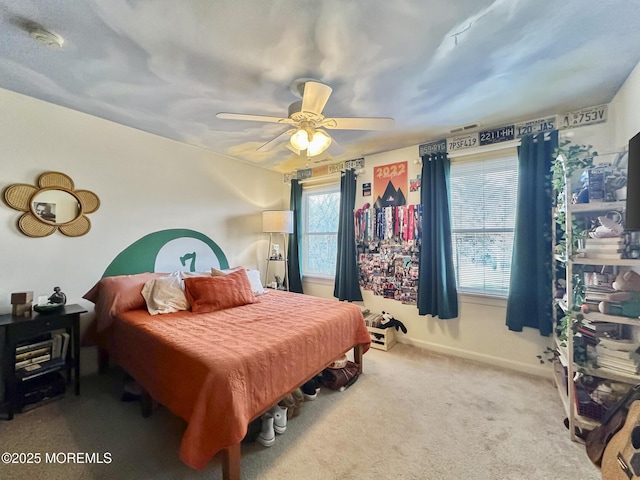 carpeted bedroom with visible vents, baseboards, and a ceiling fan