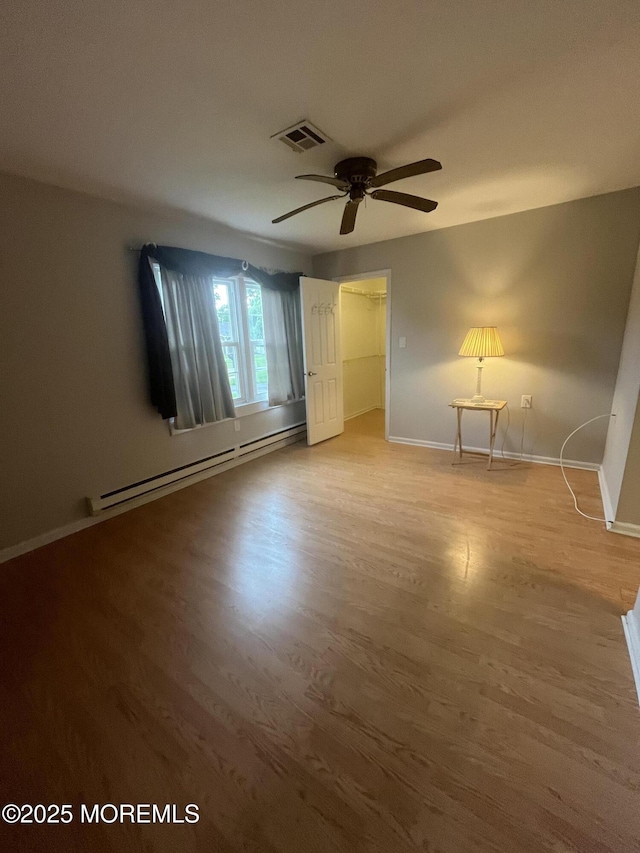 18 Andes Ct, Brick, NJ 08724 - unfurnished bedroom featuring a baseboard heating unit, baseboards, wood finished floors, and ceiling fan