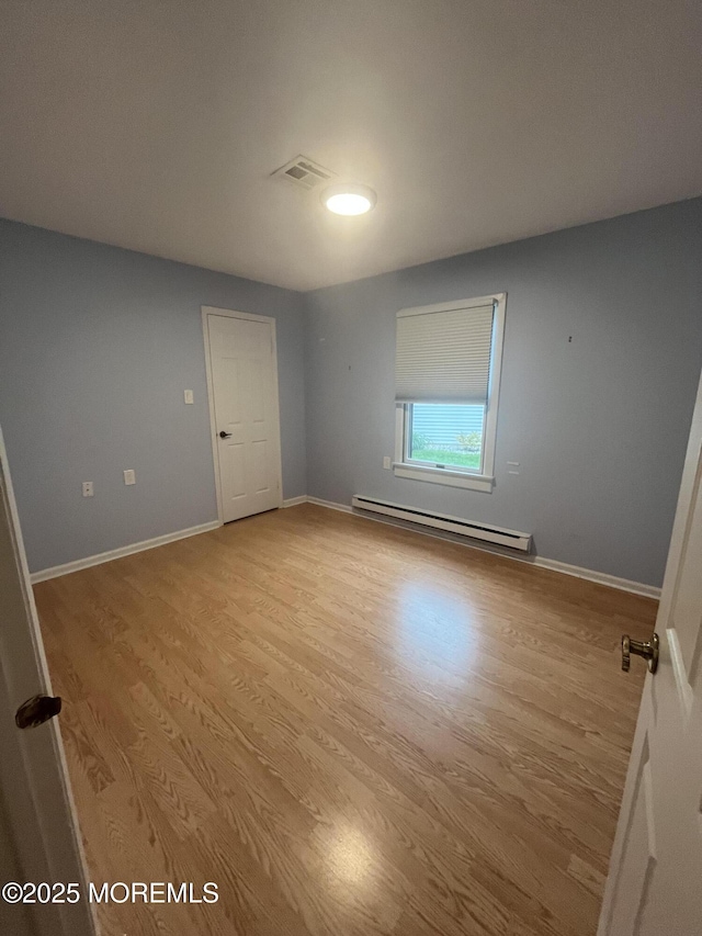 18 Andes Ct, Brick, NJ 08724 - spare room featuring a baseboard heating unit, light wood-style flooring, and baseboards