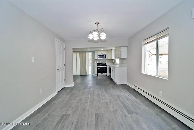 950 Bay Ave, Toms River, NJ 08753 - kitchen with an inviting chandelier, appliances with stainless steel finishes, wood finished floors, a baseboard radiator, and baseboards