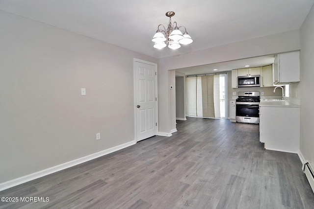 950 Bay Ave, Toms River, NJ 08753 - kitchen with baseboards, a notable chandelier, light countertops, wood finished floors, and stainless steel appliances