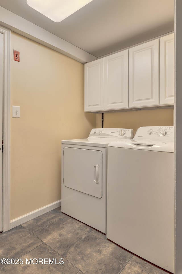 laundry room with washing machine and clothes dryer, cabinet space, and baseboards