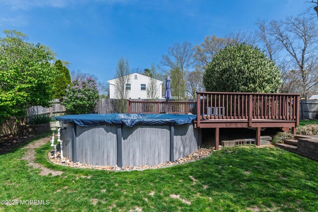 view of pool with a wooden deck, a fenced in pool, a lawn, and a fenced backyard