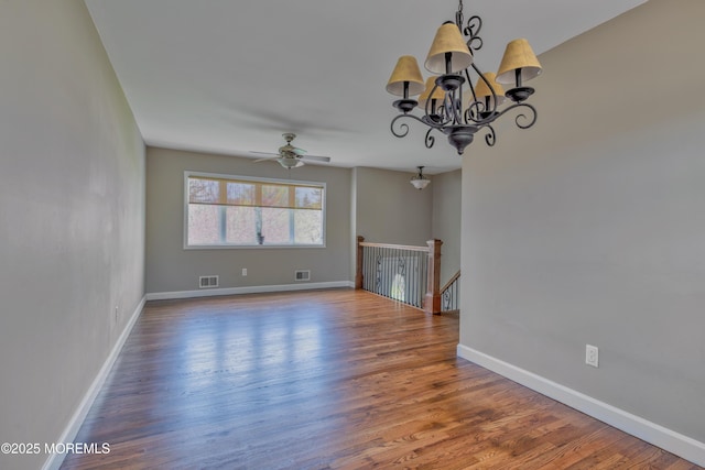 unfurnished living room with baseboards, wood finished floors, and visible vents