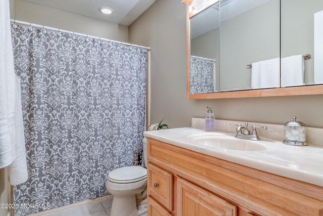 bathroom featuring tile patterned floors, vanity, and toilet