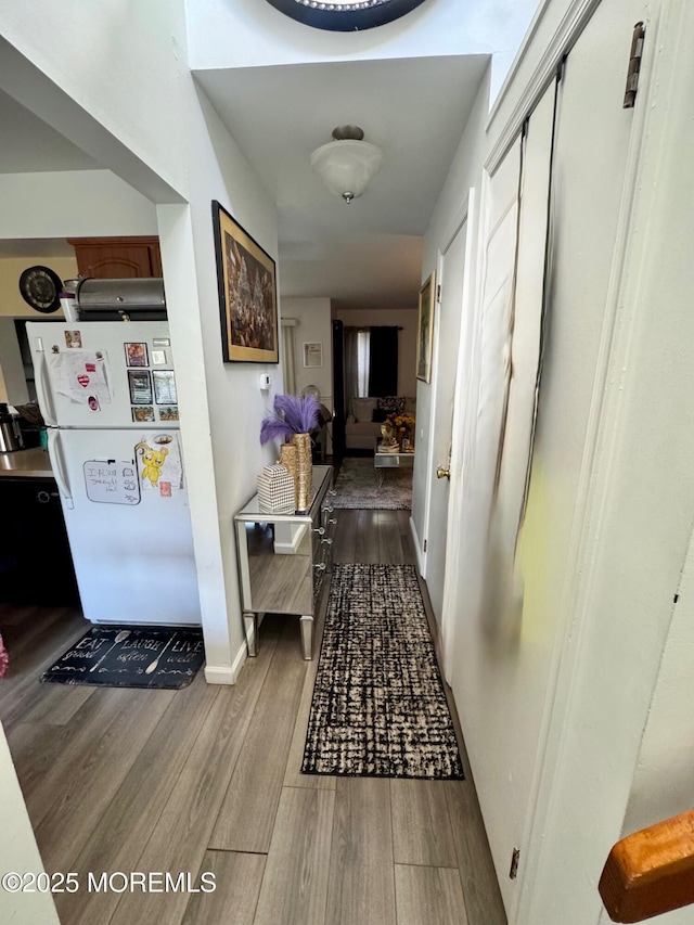 hall with baseboards and wood finished floors