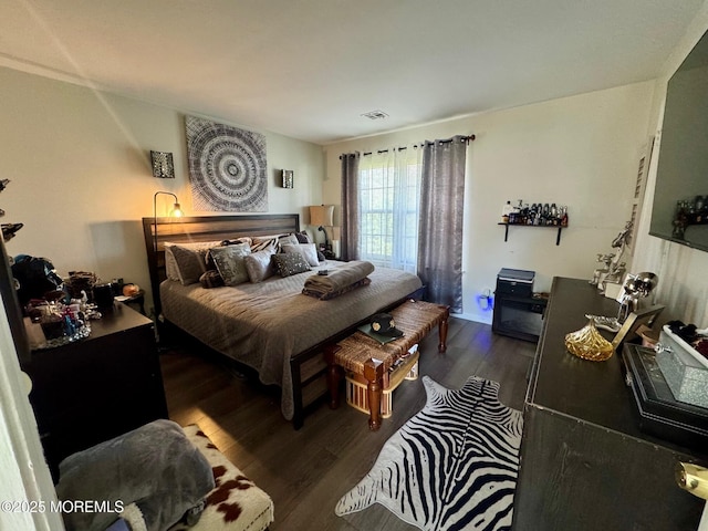 bedroom featuring wood finished floors and visible vents
