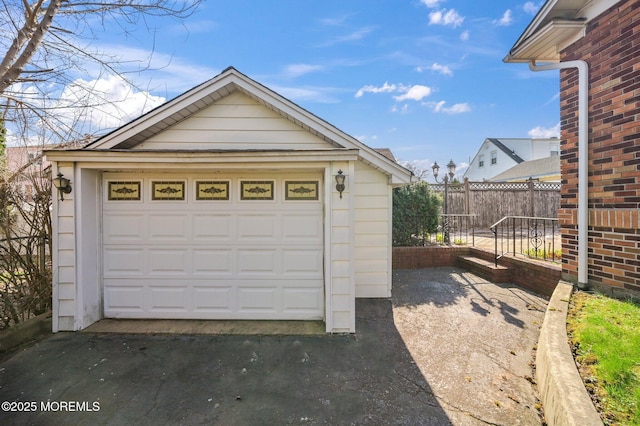 detached garage with fence and driveway