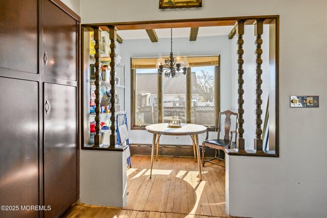 dining area featuring an inviting chandelier, beamed ceiling, and hardwood / wood-style flooring