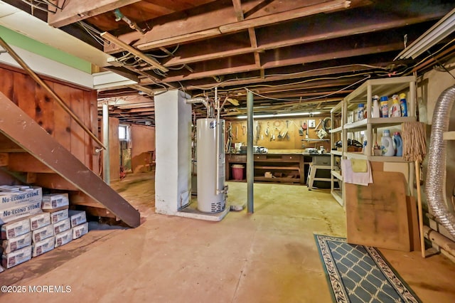 unfinished basement with stairway and water heater